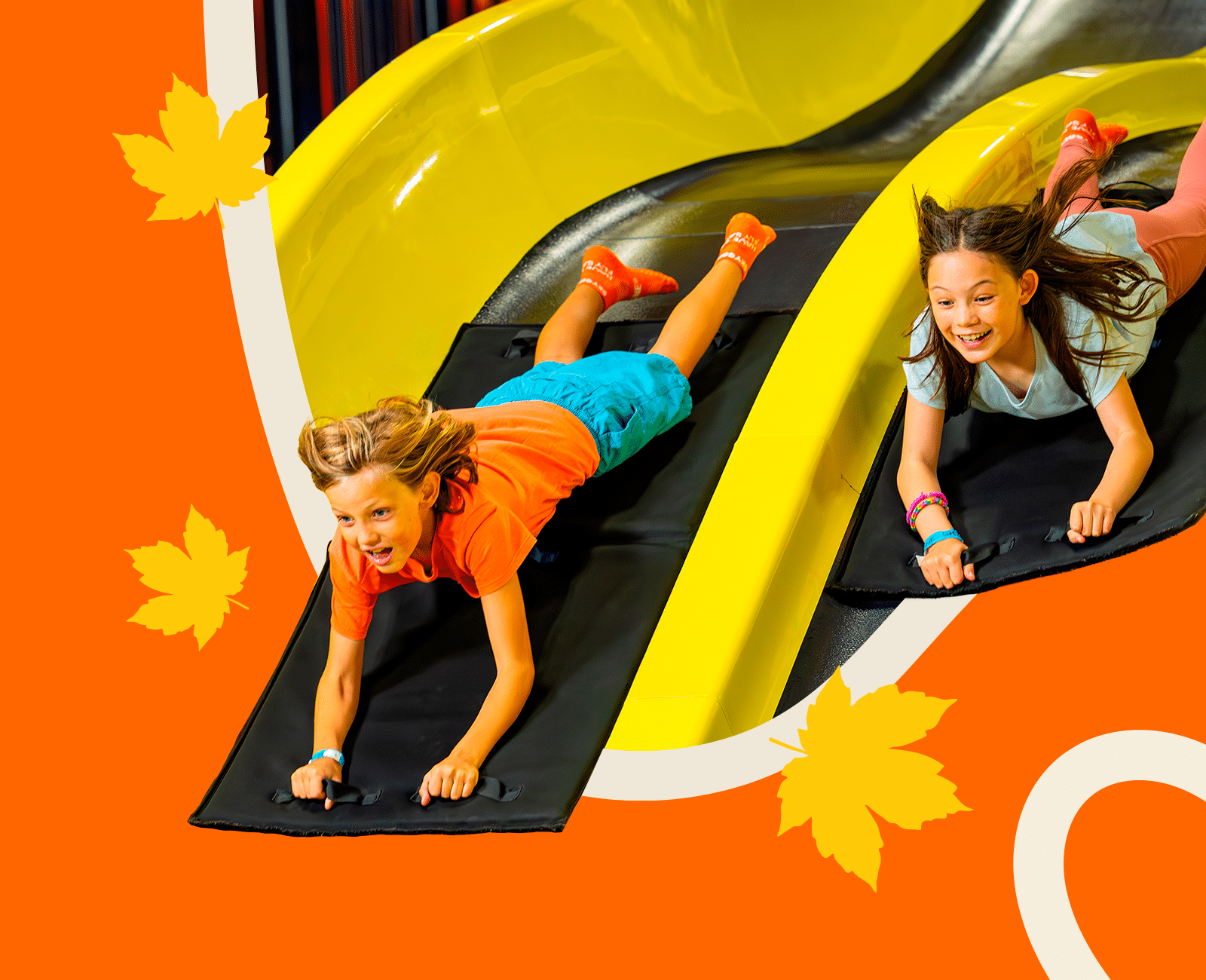 Two kids going down a slide at Sky Zone